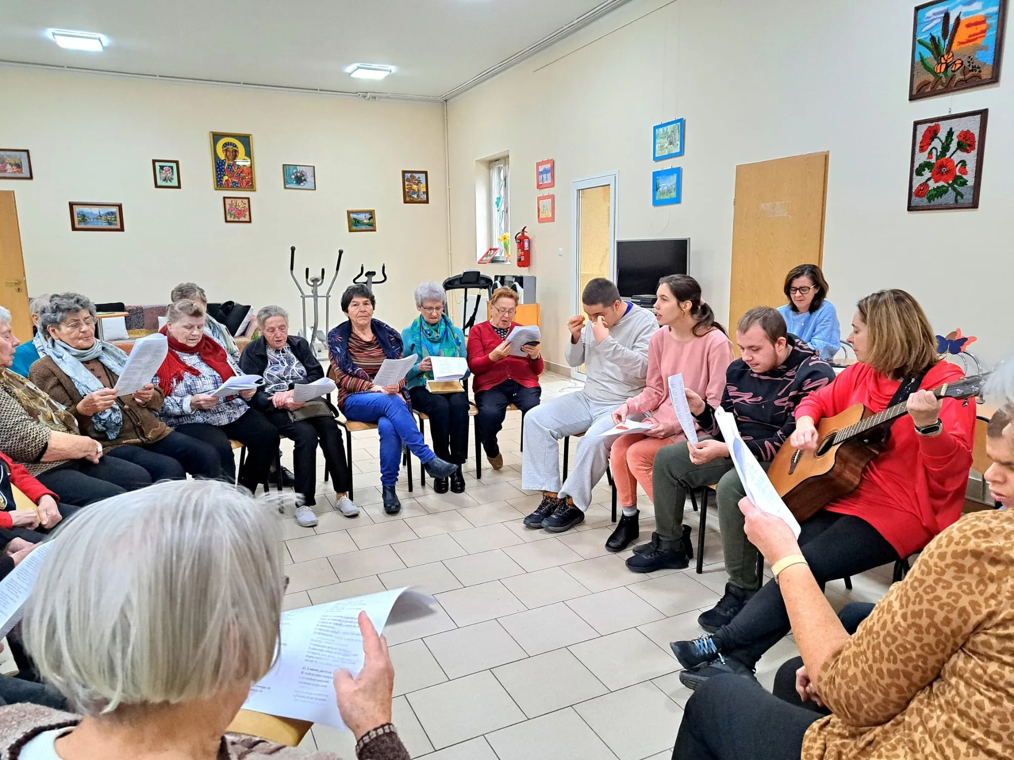 Seniorzy i uczniowie ZSS 102 wspólnie śpiewają pieśni patriotyczne.