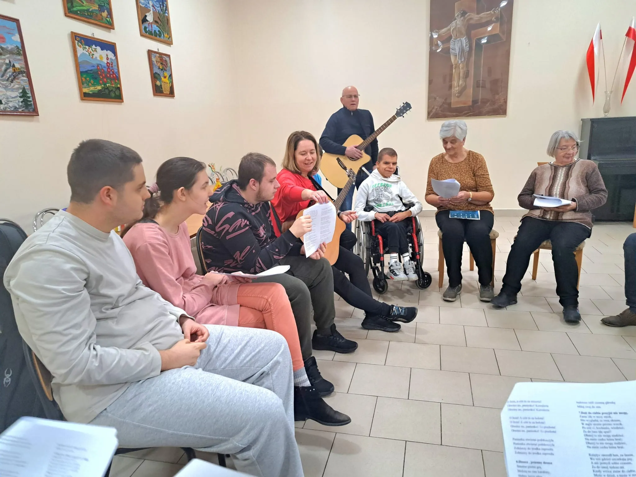 Seniorzy i uczniowie ZSS 102 wspólnie śpiewają pieśni patriotyczne.