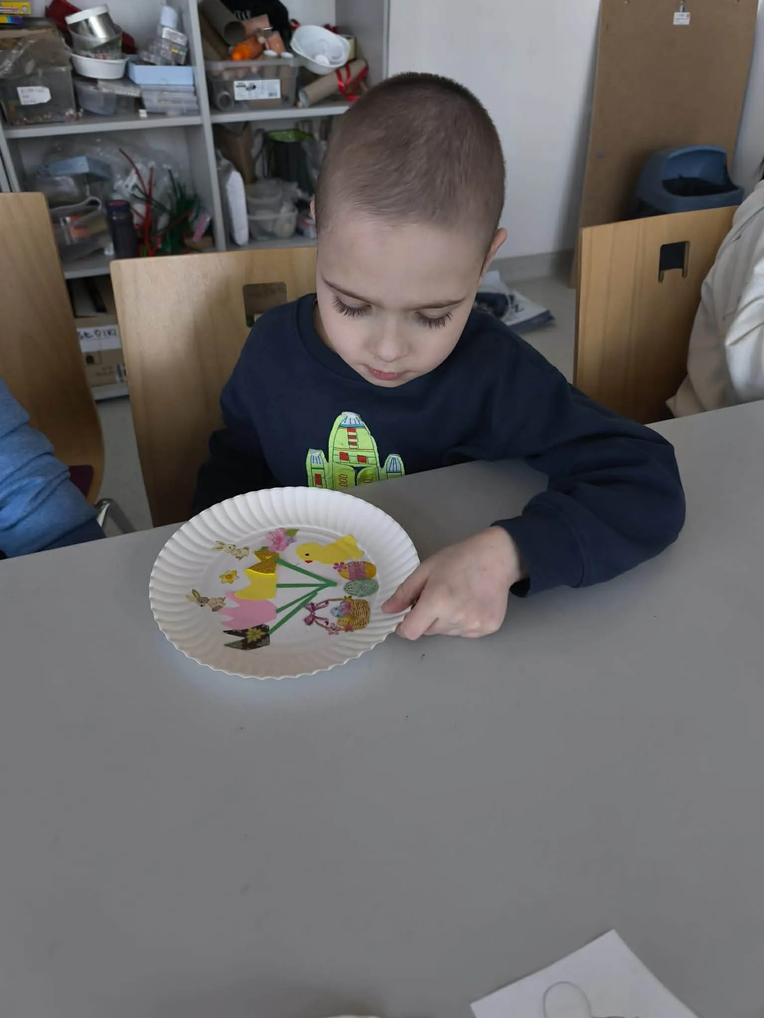 Warsztat plastyczny - chłopiec zdobi talerz