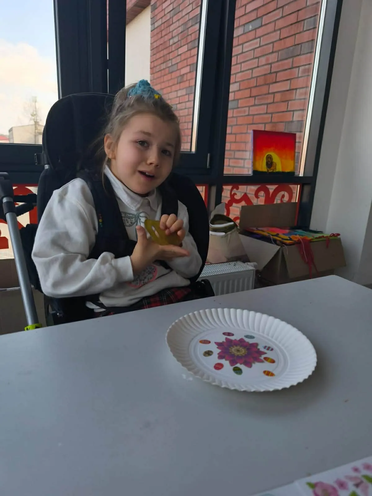 Warsztat plastyczny - dziewczynka zdobi talerz